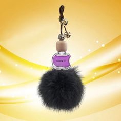 a bottle with a fur ball hanging from it's side next to a keychain