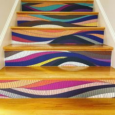 an artistic stair case with colorful waves painted on it