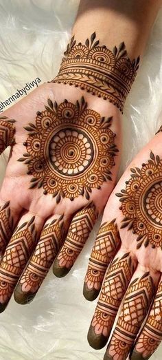 two hands with henna tattoos on them