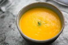 a white bowl filled with yellow liquid on top of a table