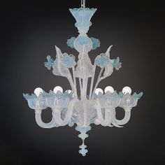 a glass chandelier hanging from the ceiling in front of a black background,