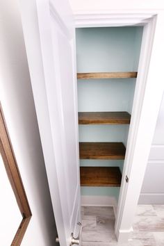 an open closet door with shelves in it