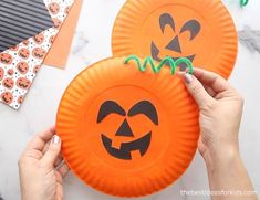 two paper plates with pumpkin faces on them