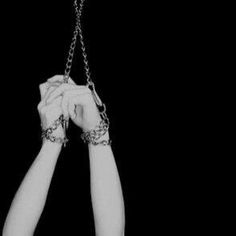 two hands are chained to each other with chains hanging from the wrist and holding them together