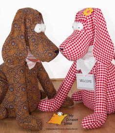 two stuffed dogs sitting on the floor next to each other wearing red and white checkered clothing