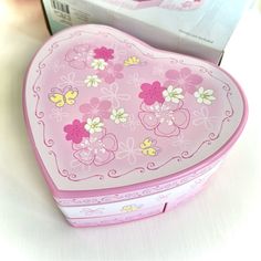 a pink heart shaped box sitting on top of a table