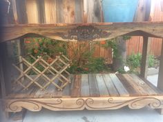 a wooden bench sitting next to a potted plant