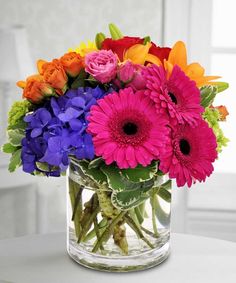 a vase filled with colorful flowers on top of a table