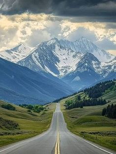 an empty road in the middle of nowhere with mountains in the background and cloudy skies