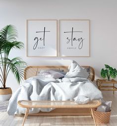 two posters on the wall above a bed in a room with white sheets and pillows