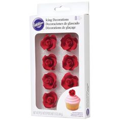 six red roses in a white box with pink frosting on the top and bottom