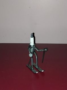 a metal figurine holding a wrench on top of a red countertop