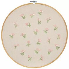 a white wall hanging with pink flowers on it