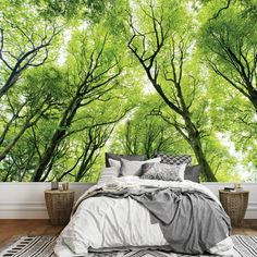 an image of a bedroom with trees on the wall and bed in the foreground