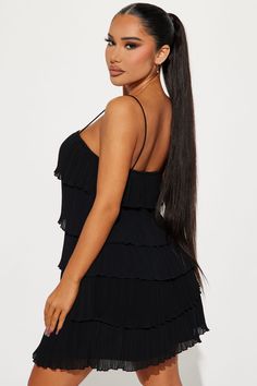 a woman with long hair wearing a black dress