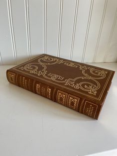 a brown book sitting on top of a white table