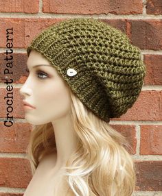 a mannequin head wearing a green knitted hat with a button on it