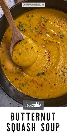 a bowl of butternut squash soup with a wooden spoon