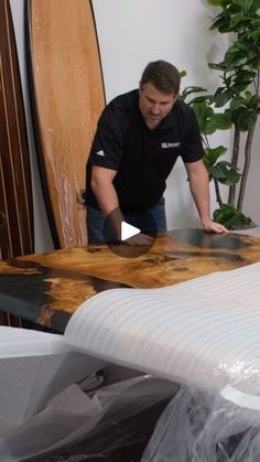 a man working on a surfboard in a room