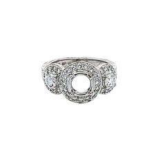 a white gold ring with three diamonds on the side and an open circle in the middle