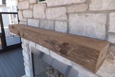 a stone fireplace with a wooden mantle