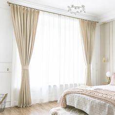 a bedroom with white walls and wood flooring is pictured in this image, the curtains are open