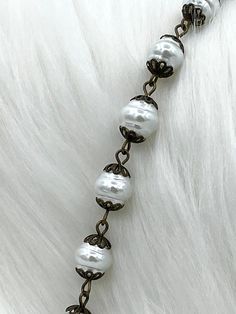 Are you looking for a beautiful rosary chain to add to your jewelry designs? Look no further than our Glass Pearl Beaded Rosary Chain! This chain is made with 9mm pearls and comes in five styles: white pearls with bronze wire, white pearls with silver wire, white pearls with gold wire, white pearls with matte gold wire, and rose dust pearls with bronze wire. It is sold by the foot, and multiple feet will come in a continuous strand. Plus, orders placed by 11:00 am EST Monday-Friday ship the same Elegant Beaded Rosary For Jewelry Making, Nickel-free White Necklace With Round Beads, White Nickel-free Necklace With Round Beads, White Oval Beaded Chain Jewelry, Elegant Pearl Rosary With Round Beads, Elegant Rosary Bracelet With 8mm Beads For Jewelry Making, Elegant Pearl White Rosary With Round Beads, White Jewelry With Oval Spacer Beads, Elegant Beaded Rosary With Round Beads