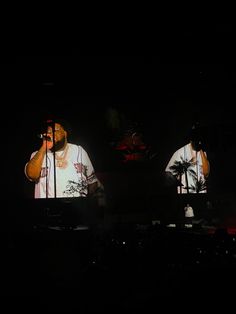 two people on stage with microphones in their hands