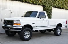 a white pick up truck parked in front of a building