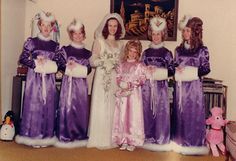 a group of women in purple dresses standing next to each other