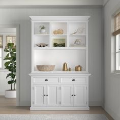 a living room with white furniture and a potted plant