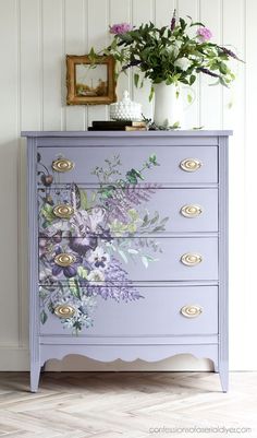 a purple dresser with flowers painted on it