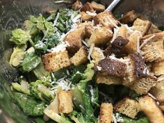 a salad with croutons, broccoli and parmesan cheese in it