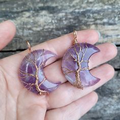 These highly polished natural Amethyst crescent moon shaped stones have been wrapped in silver and copper wire to form the tree of life, which represents peace and immortality. The handmade pendant measures 1-1/2" tall by 1-1/4" wide and will come on a matching color chain (silver, copper or rose gold) or a black leather cord in the length of your choice. Natural Amethyst stone is one of nature’s most potent amplifiers of inner peace, positive transformation, balance, and healing of body, mind and soul. Amethyst has also been known for protecting the wearer from nightmares and insomnia, which makes it the perfect healing gift for your friends and loved ones!Chain Type Options:If you want a Silver wire wrapped stone with silver color chain, Select (Silver Wire & Chain)If you want a Silver w Moon Tree Of Life, Tree Of Life Wire, Moon Tree, Healing Stones Jewelry, Tree Of Life Jewelry, Amethyst Healing, Wire Wrapping Stones, Rose Gold Chain, Celestial Jewelry