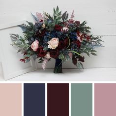 a vase filled with flowers and greenery on top of a white table next to a wall