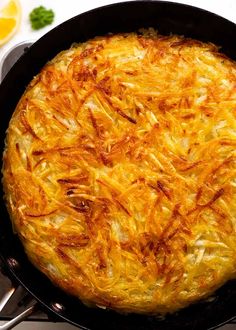 an omelet in a cast iron skillet on top of a stove with utensils next to it