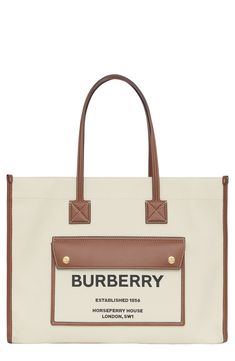 Pre-order this style today! Add to Shopping Bag to view approximate ship date. You'll be charged only when your item ships.Burberry's Horseferry logo is stamped on the front pocket of this versatile tote that has a casual feel in neutral-hued canvas and topstitched leather trim. Open top Top carry handles Exterior magnetic-flap pocket Interior zip pocket Canvas with leather trim Made in Italy Designer Handbags Brown Bags With Embroidered Logo For Shopping, Classic Bags With Embroidered Logo For Daily Use, Coated Canvas Bag With Embroidered Logo For Everyday Use, Everyday Coated Canvas Bag With Embroidered Logo, Everyday Bags With Embroidered Logo In Coated Canvas, Everyday Bags With Embroidered Logo On Coated Canvas, Everyday Bags With Embroidered Logo And Coated Canvas, Beige Cotton Bag With Logo, Beige Cotton Bags With Logo