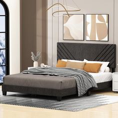 a bedroom with a bed, dressers and windows in it's center area