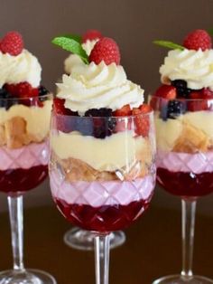 three glasses filled with dessert sitting on top of a table