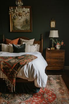 a bedroom with a bed, dresser and painting on the wall above it's headboard