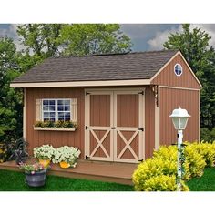 a garden shed with plants and flowers in the yard