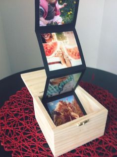 three pictures are placed in a wooden box on top of red yarn and the bottom one is turned upside down