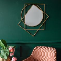 a green room with a chair, mirror and potted plant on the side table