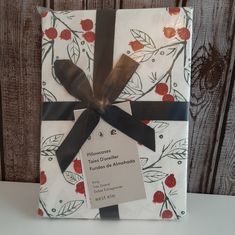 a gift wrapped in wrapping paper with a black ribbon