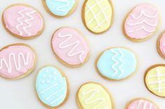 decorated cookies with pastel and white icing are arranged in a circle on a table