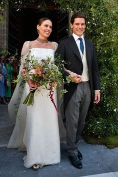 a man and woman in formal wear standing next to each other with flowers on their wedding day