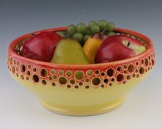 a bowl filled with fruit sitting on top of a table