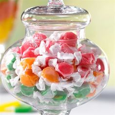 a glass bowl filled with gummy bears on top of a table