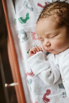 a baby is sleeping in a crib with his hands on his chin and eyes closed