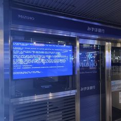 a large screen in the middle of a train station with information on it's side